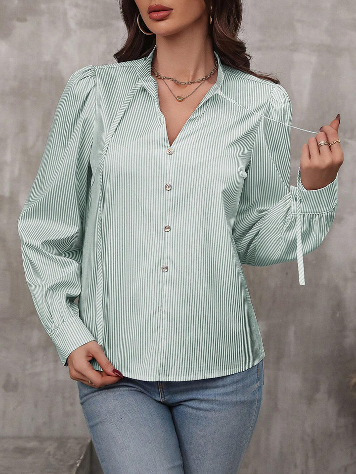 Dame elegant stribet bluse med puffærmer og fine knapdetaljer Stilla