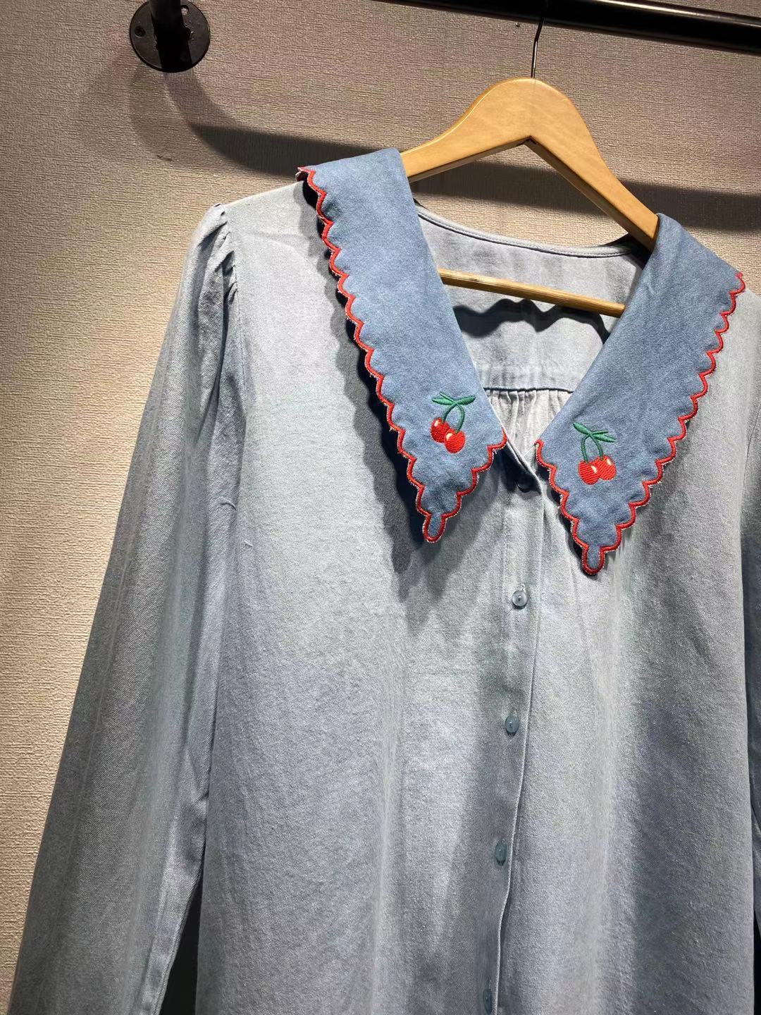 Damebluse med stor, bølget krave og broderede detaljer Stilla