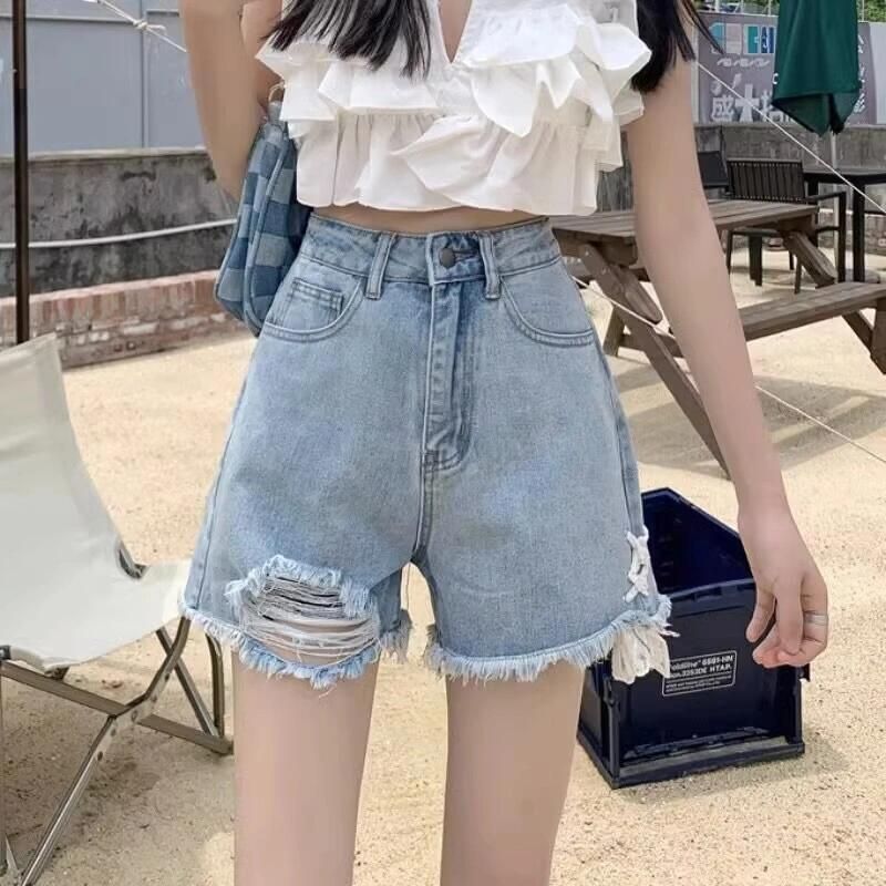 Dame denim shorts med trendy ødelagte detaljer og håndlavede accenter