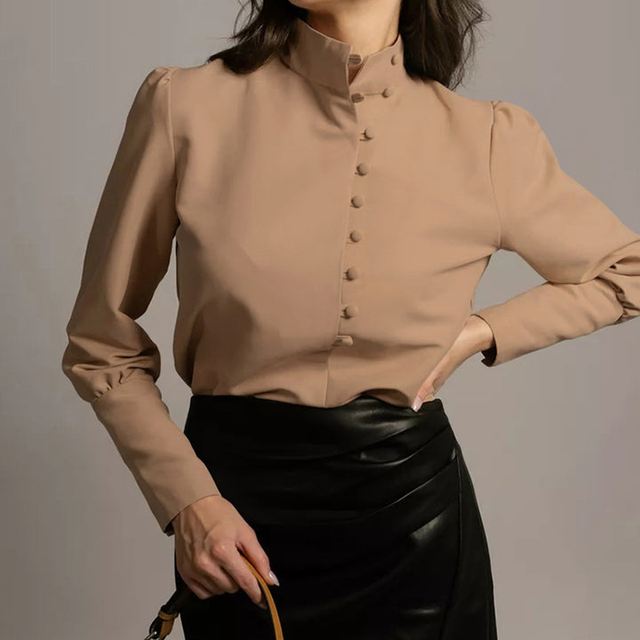Damebluse med høj ståkrave og elegante pufærmer Stilla
