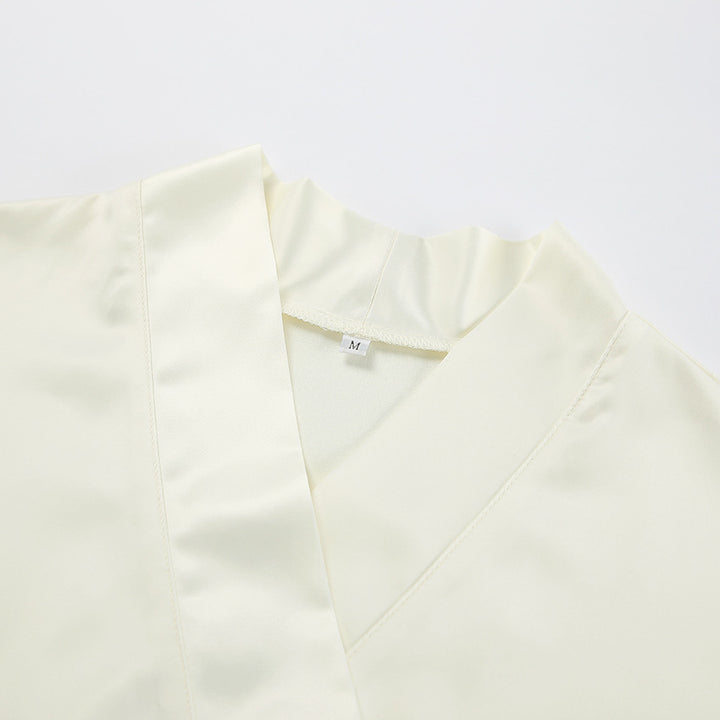 Dame Satin- jumpsuit med elegant omslag design og svajende kant Stilla