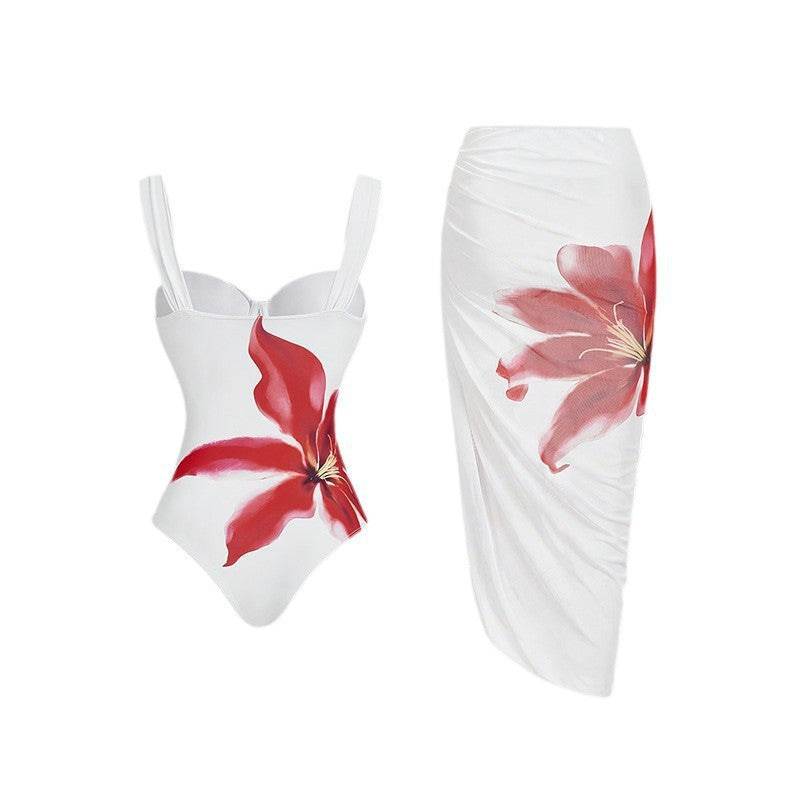 Dame one-piece badedragt med elegant blomsterapplikation og draperet skørt Skovae