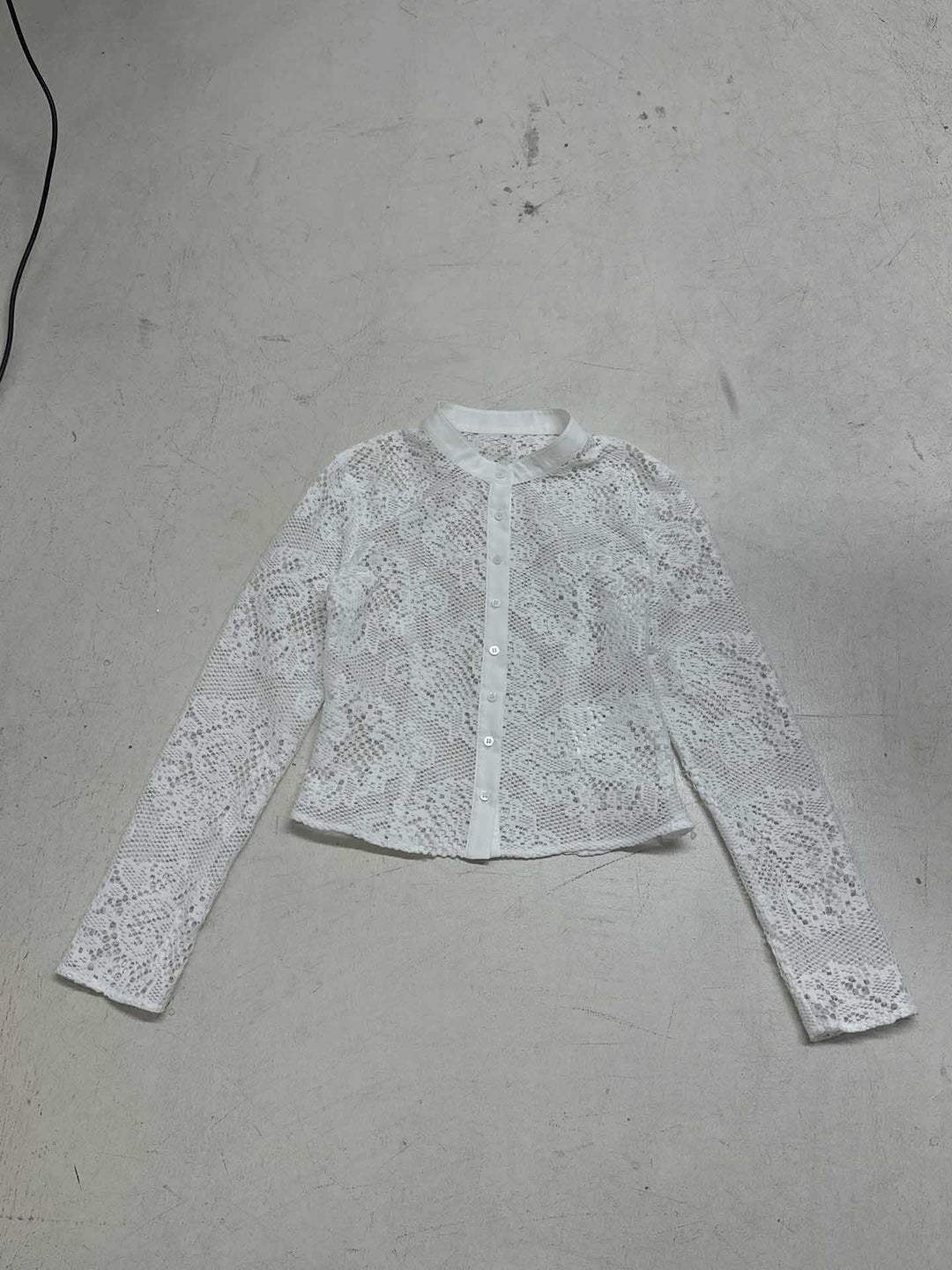 Dame spidsbluse med transparente accenter og elegant knaplukning Skovae