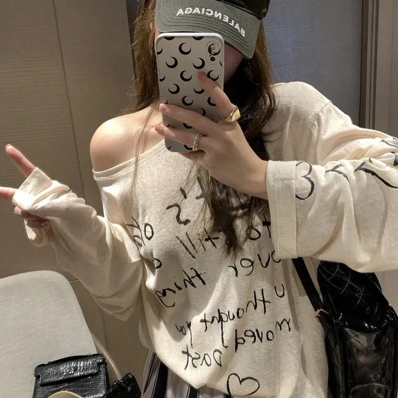Kvinders afslappede oversized top med off-shoulder design og kunstnerisk skrifttype Stilla