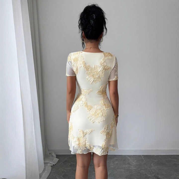 Dame nan figurbetont Tüll-minikjole med tredimensionel blomsterbroderi, foran slidse og korte transparente ærmer Skovae