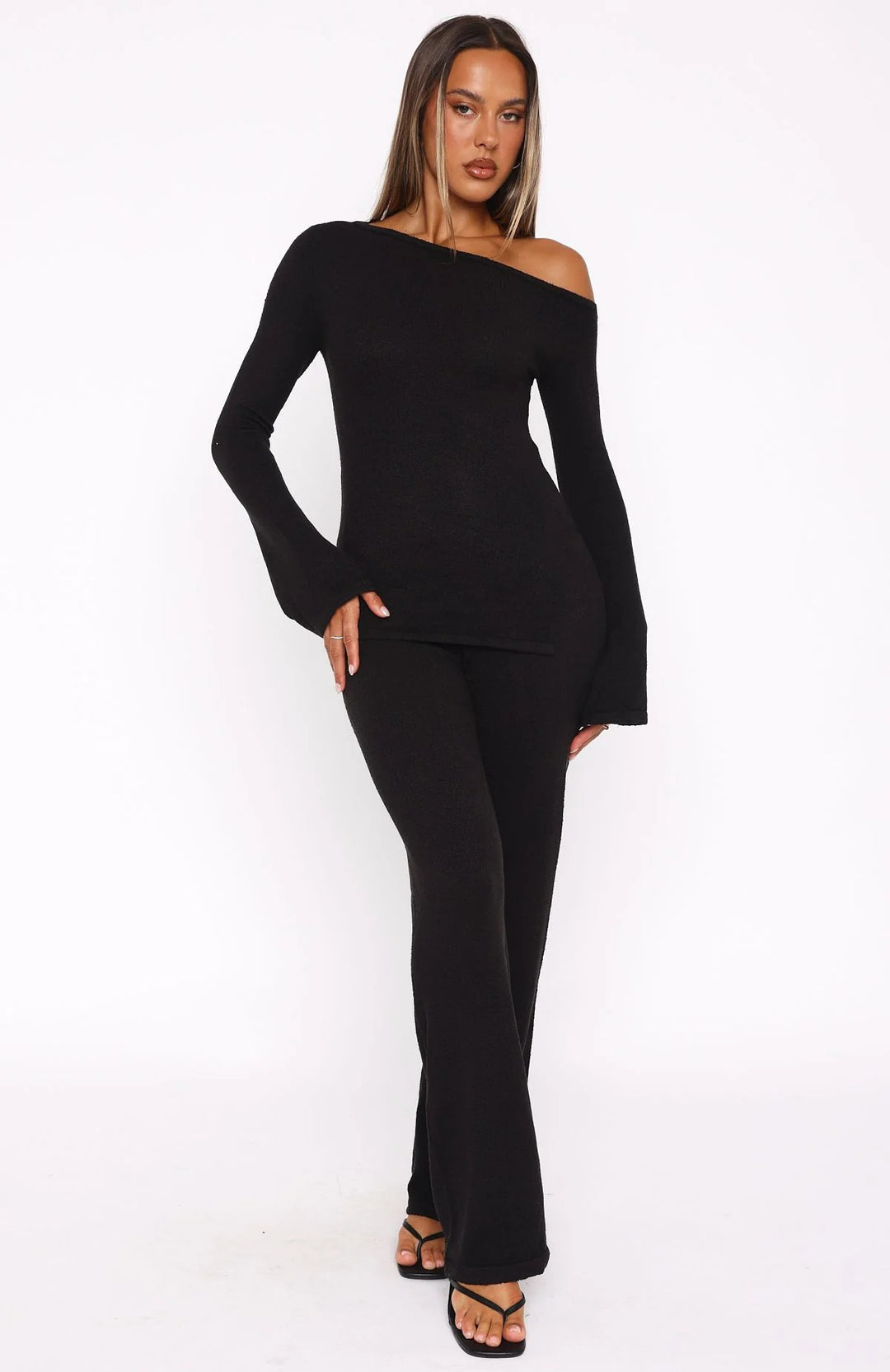 Dame stilfuld strik ensemble med asymmetrisk top og bred ben