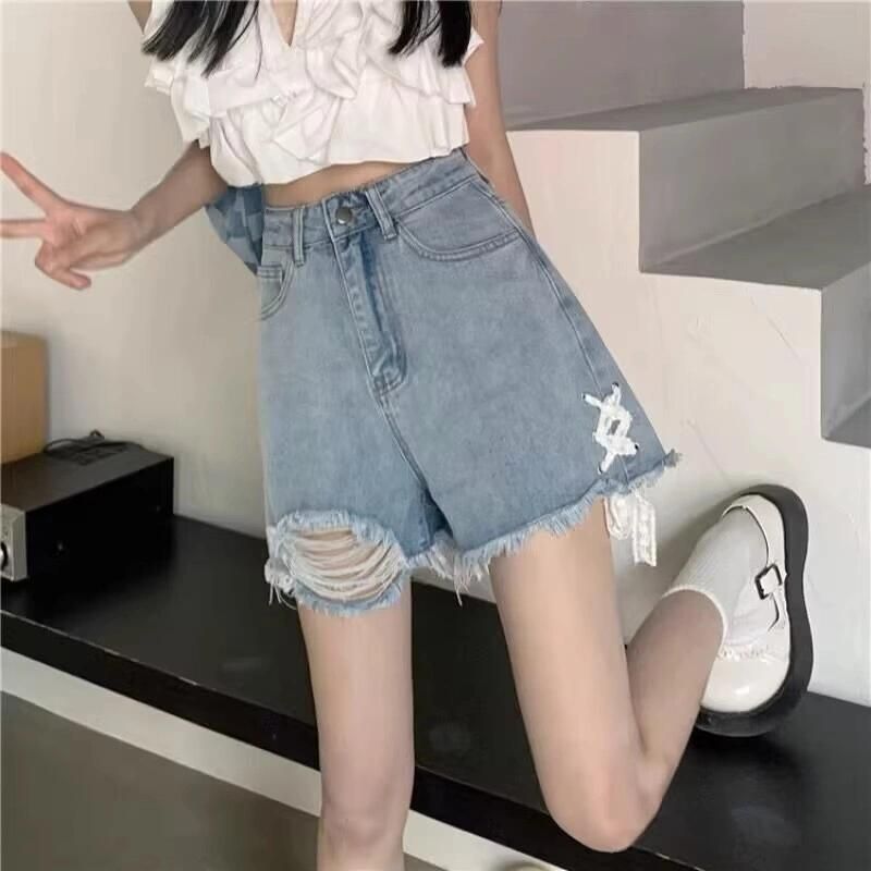 Dame denim shorts med trendy ødelagte detaljer og håndlavede accenter