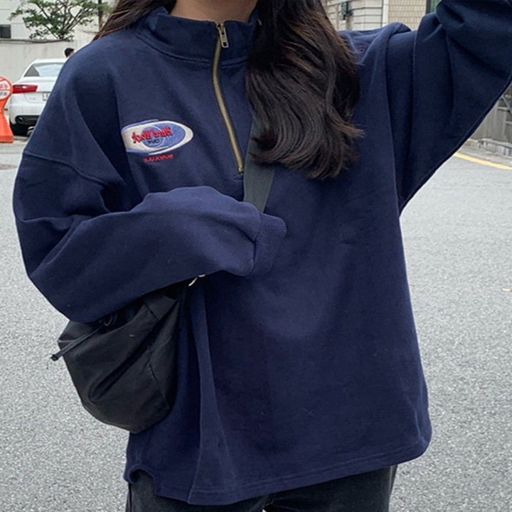 Dame afslappet sweater med praktisk halv lynlås og broderet logo Stilla