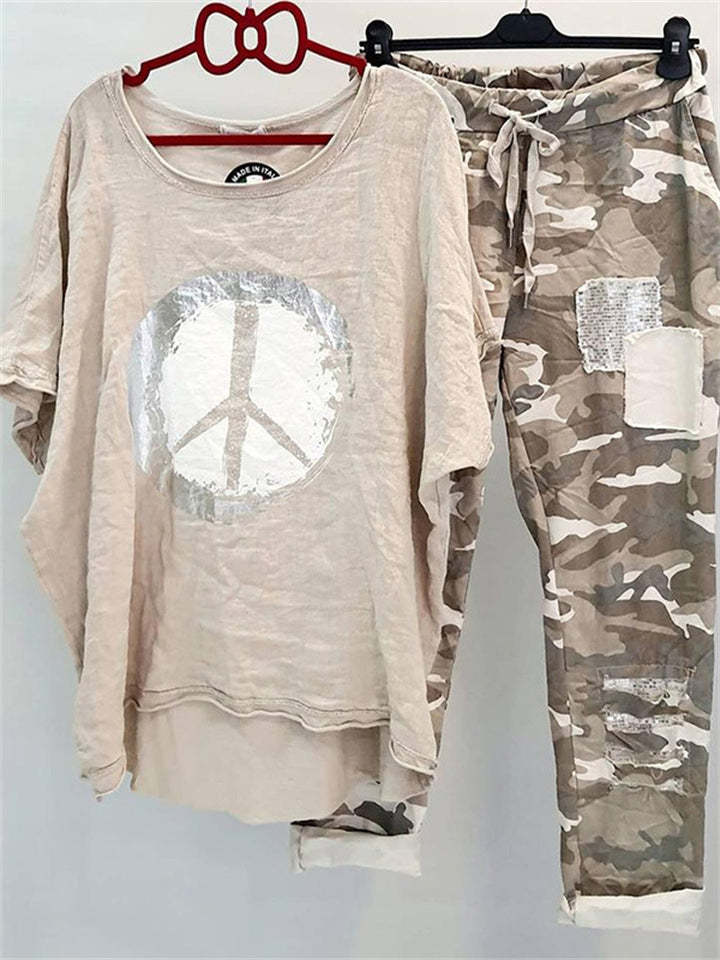 Damer med et afslappet fritidssæt med løst skåret linned-look t-shirt, fredssymbol og camouflage-joggingbukser med patchdetaljer Skovae