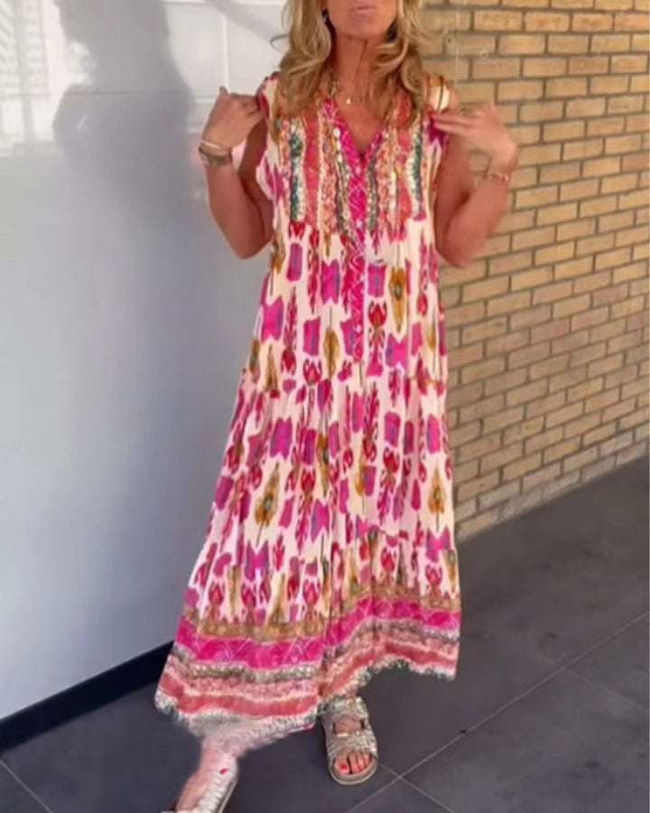 Dame i flydende maxikjole i boho-stil med V-udskæring, stribet nederdel og broderet pas Skovae