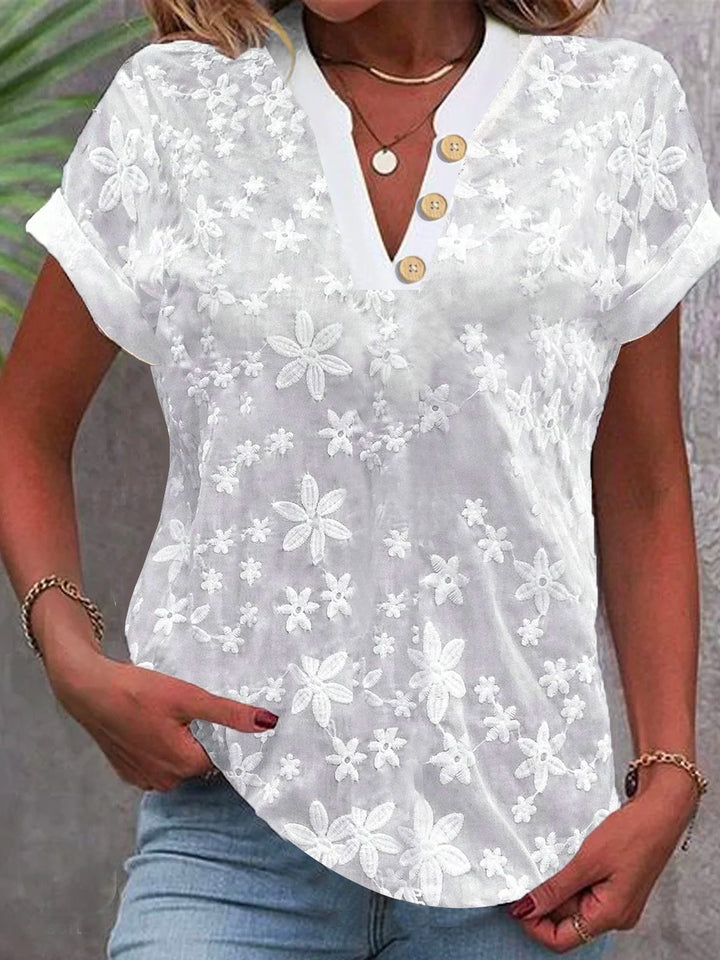 Damebluse med feminint blomsterbroderi-mønster Stilla