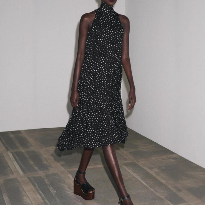 Dame med ærmeløs højhalset midikjole med svajende flæserock og feminin A-linje Skovae
