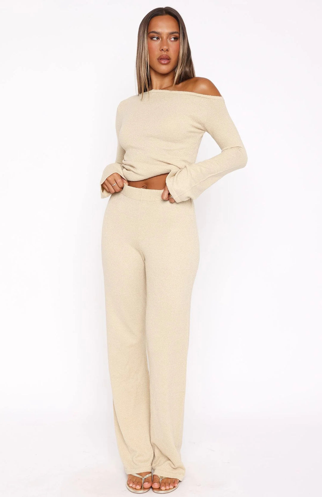 Dame stilfuld strik ensemble med asymmetrisk top og bred ben
