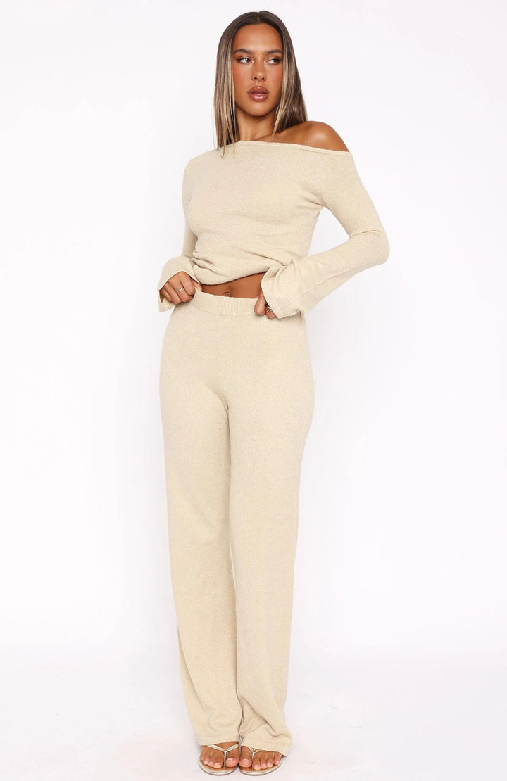 Dame stilfuld strik ensemble med asymmetrisk top og bred ben