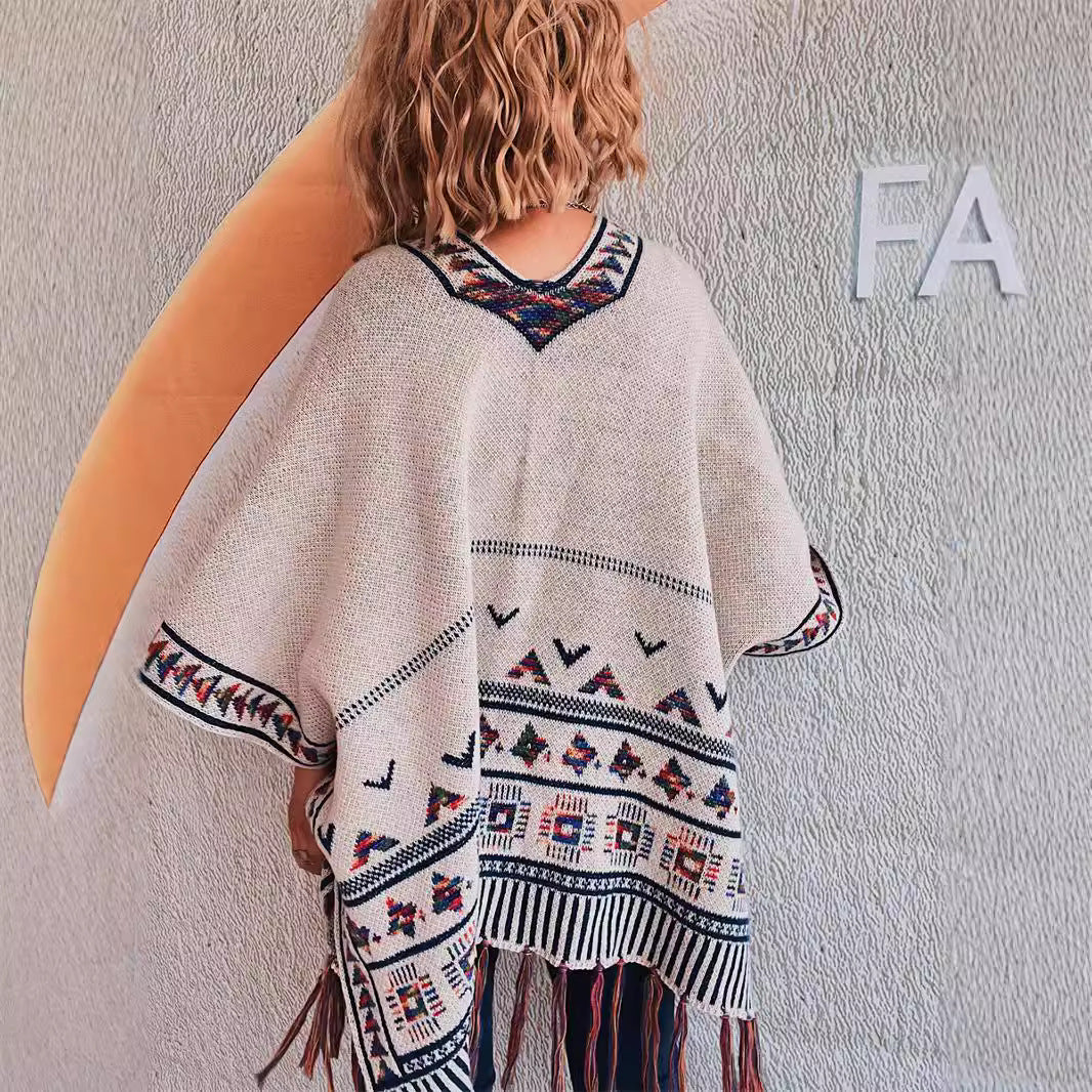 Damer fashionabel strikket poncho med frynset kant og farverigt mønster Stilla
