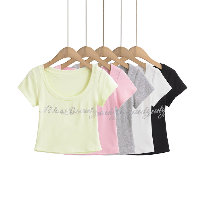 Dame crop-top med elegant rund hals og glitrende skrift Stilla
