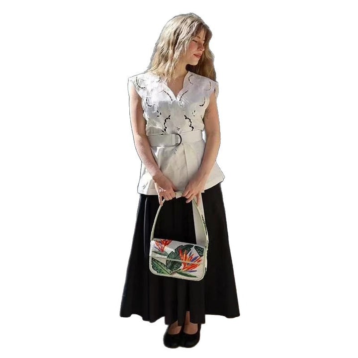 Damebluse med elegant hulmønster og floralt applikationsdesign Stilla