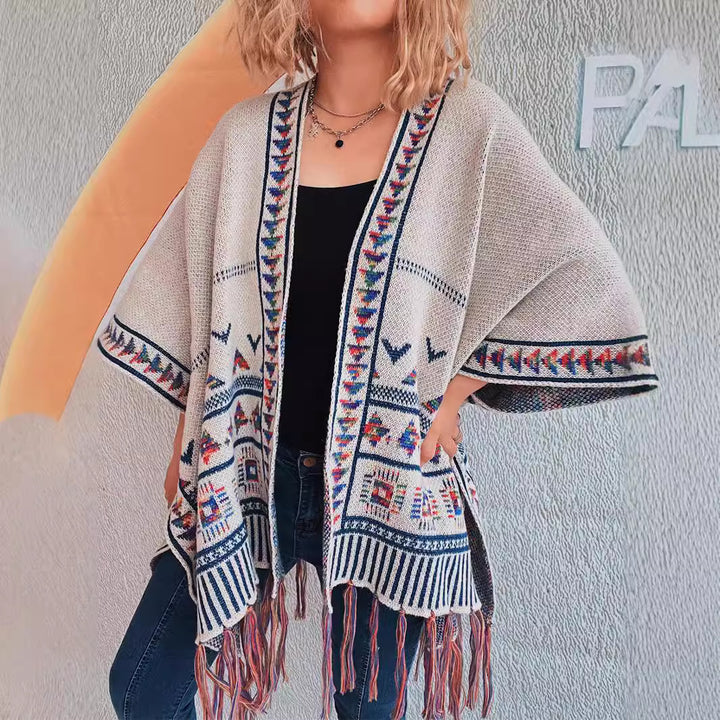 Damer fashionabel strikket poncho med frynset kant og farverigt mønster Stilla