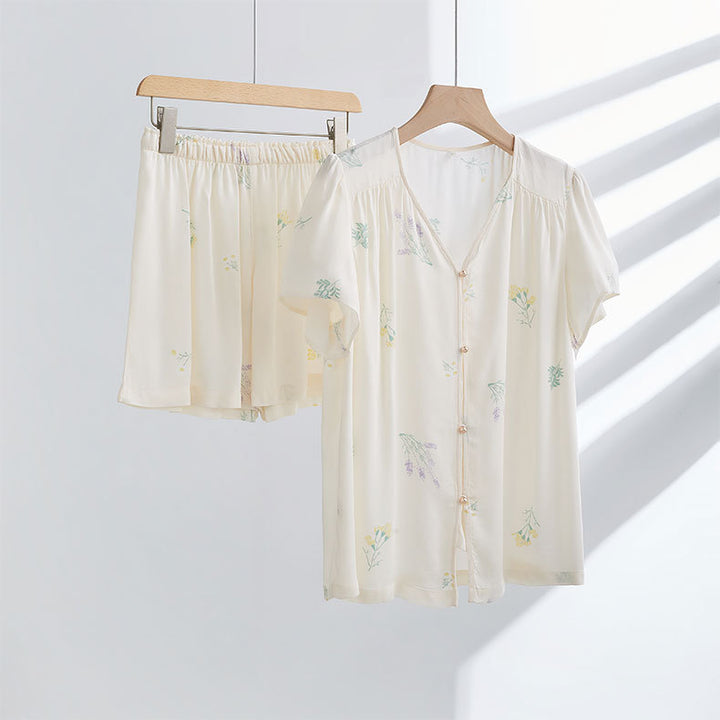 Dame pyjamasæt med elegant blomstret design og gennemgående knaplukning Stilla