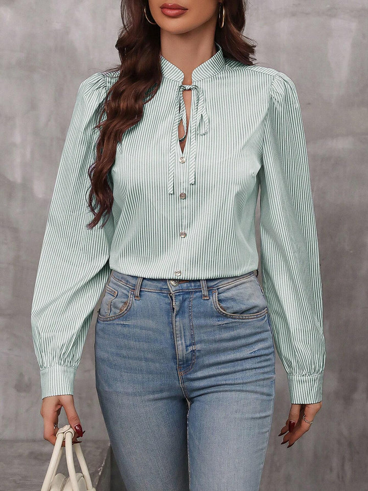 Dame elegant stribet bluse med puffærmer og fine knapdetaljer Stilla