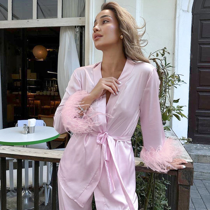 Dame elegant satin-pyjamasæt med modische fjerdetaljer Stilla