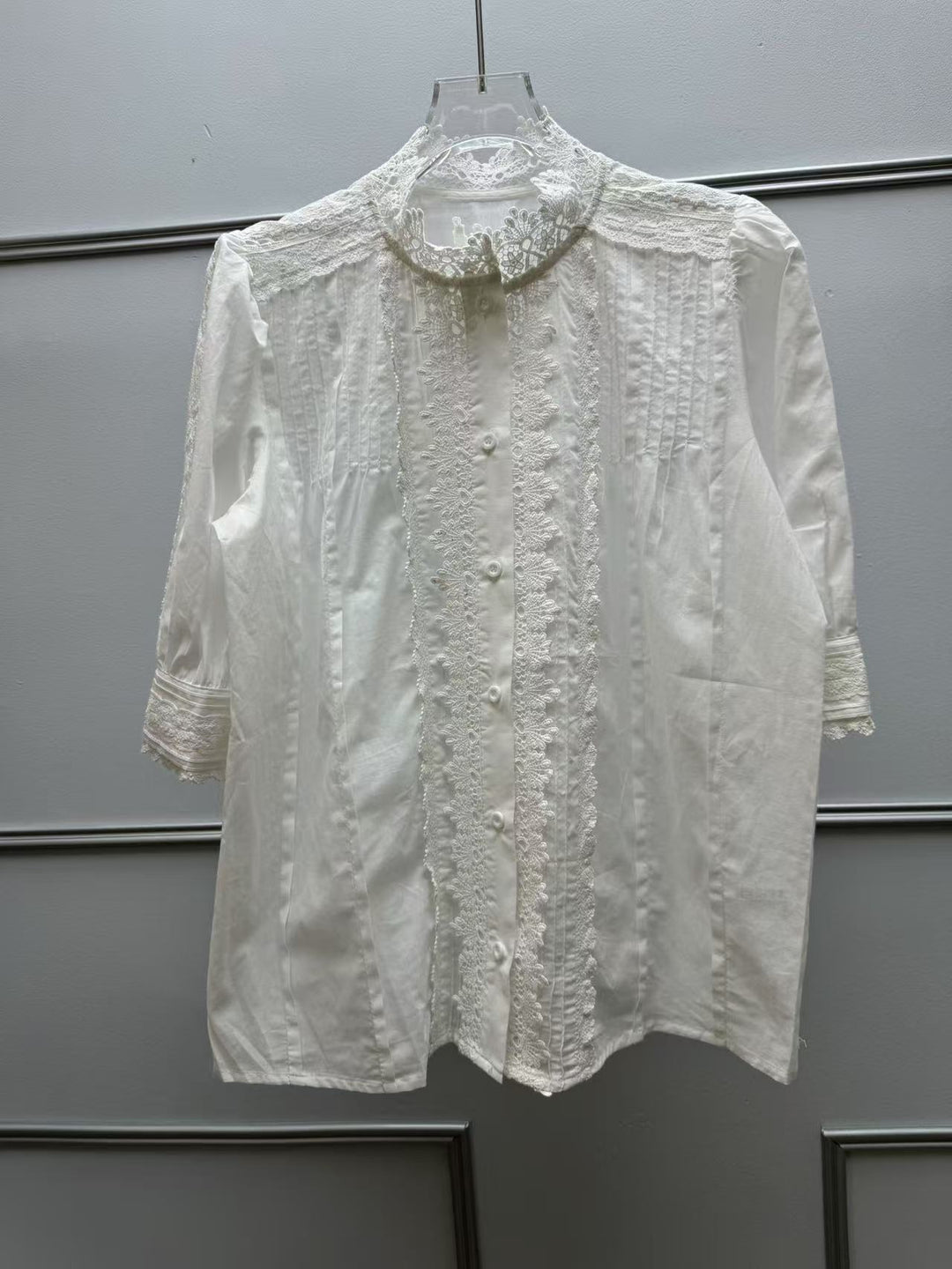Damebluse med filigrane spidsdetaljer og dekorative knapper Stilla