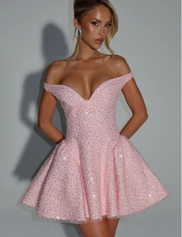 Kvindelige fortryllende cocktailkjoler med off-shoulder design og glitrende detaljer af perler Skovae