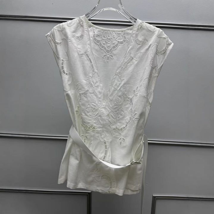 Damebluse med elegant hulmønster og floralt applikationsdesign Stilla