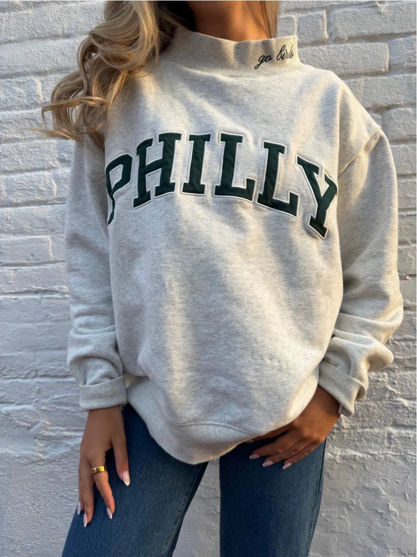 Dame med vid skåret college-sweatshirt med høj krave og påsyet skrift Skovae