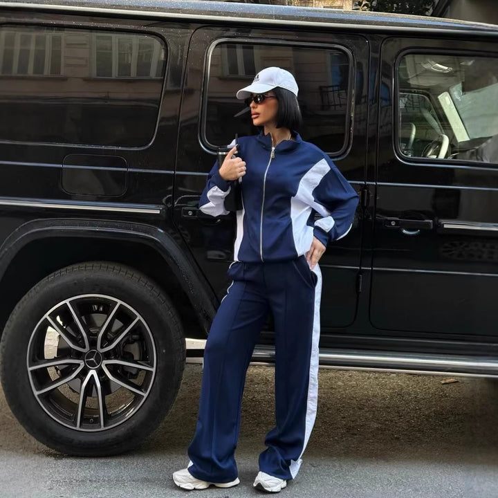 Kvinders træningsdragt med høj krave og praktiske lynlåse