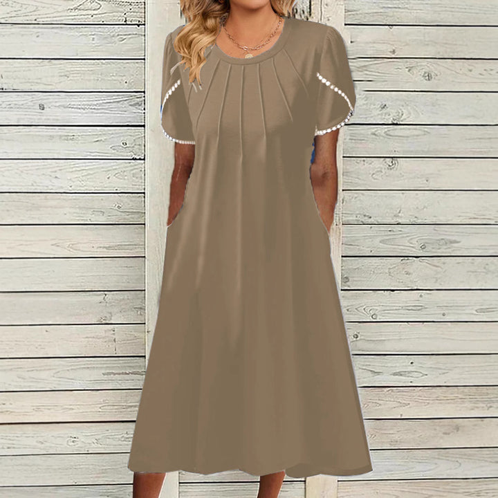 Dame fritidskjole med elegante draperinger og praktiske lommer Stilla