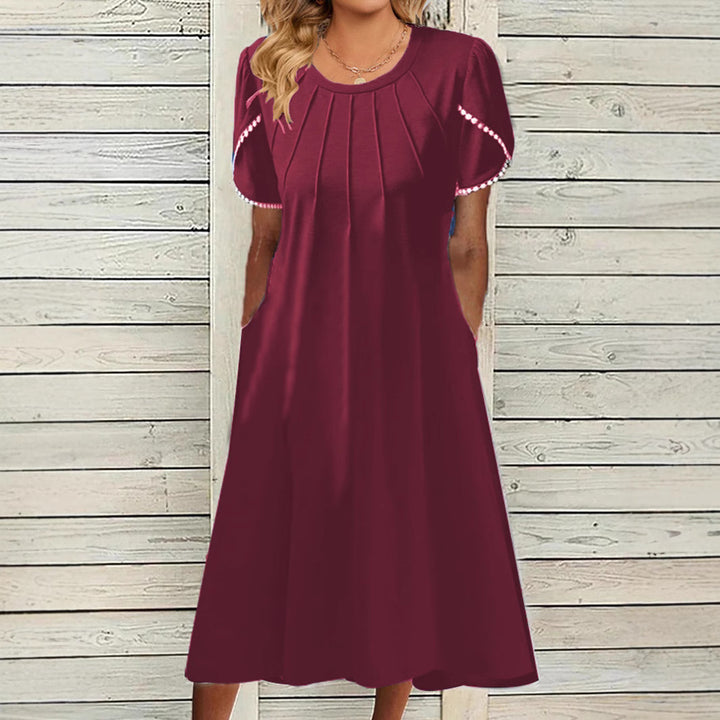 Dame fritidskjole med elegante draperinger og praktiske lommer Stilla
