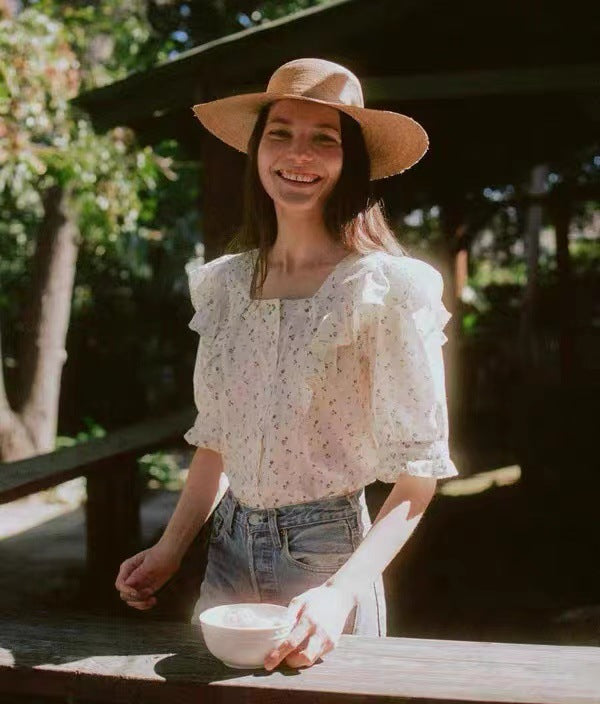 Damebluse med elegante flæsedetaljer og blomstret mønster Stilla
