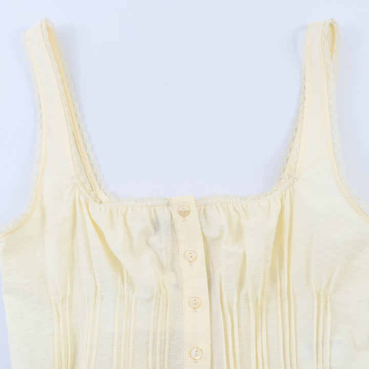 Dame-crop-top med fine folder og dekorknapper Skovae
