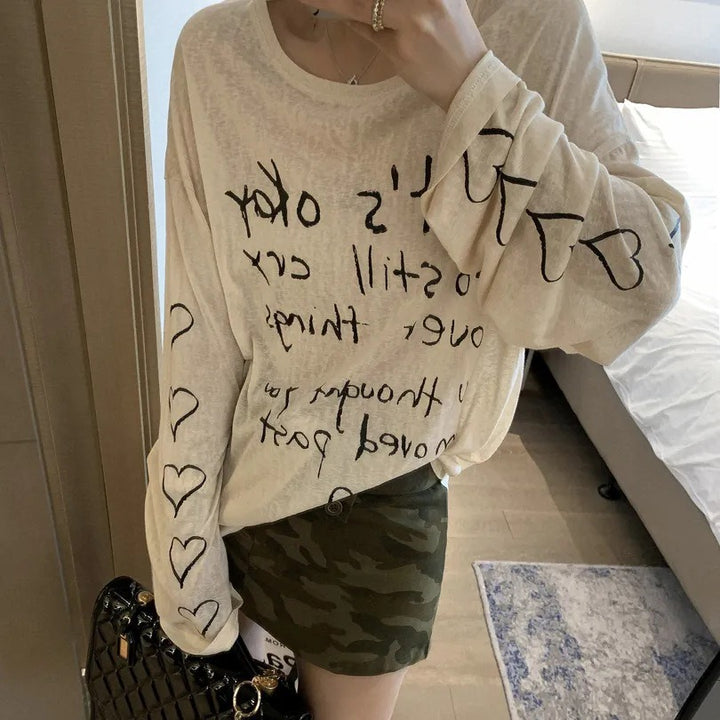 Kvinders afslappede oversized top med off-shoulder design og kunstnerisk skrifttype Stilla