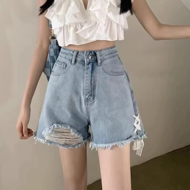 Dame denim shorts med trendy ødelagte detaljer og håndlavede accenter
