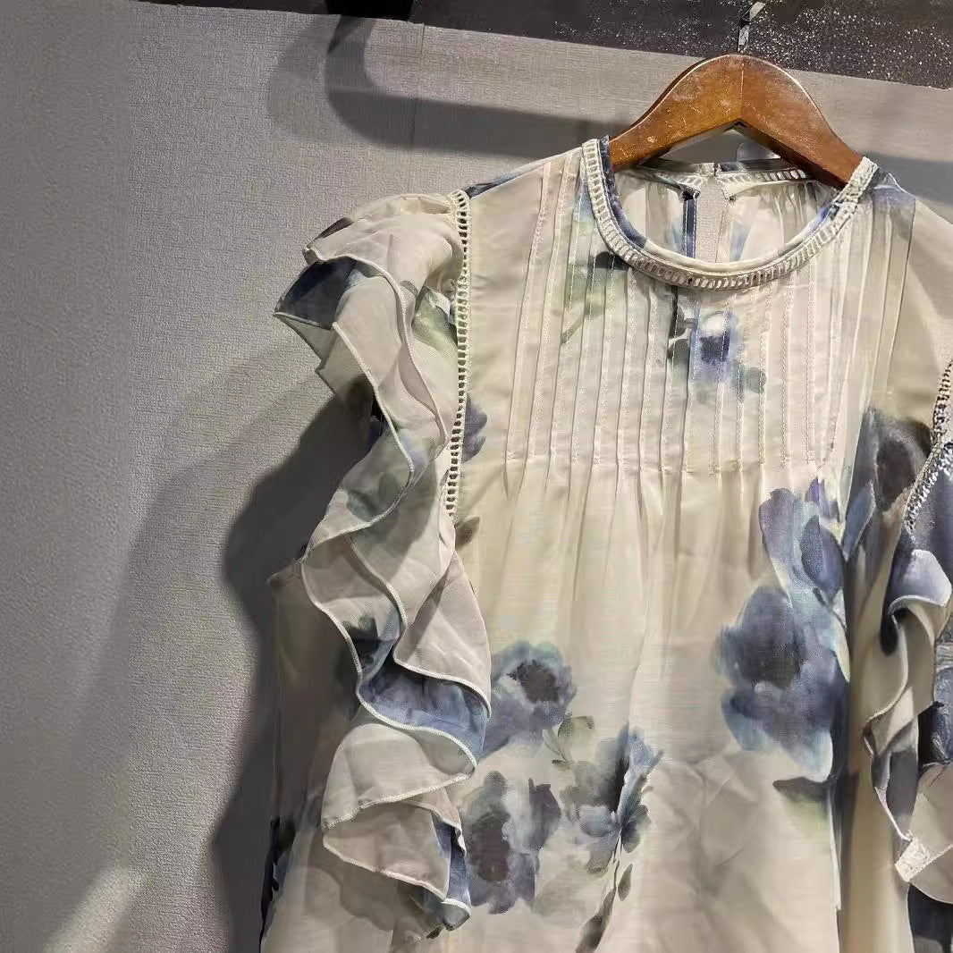 Damebluse med overdådige flæsedetaljer og sarte blomsterdesign Stilla