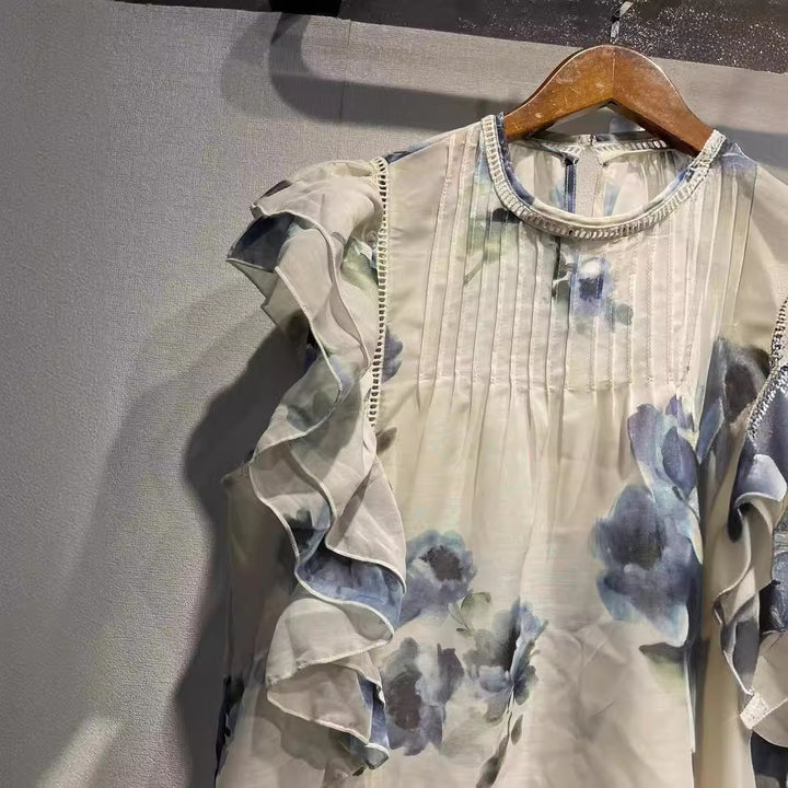 Damebluse med overdådige flæsedetaljer og sarte blomsterdesign Stilla