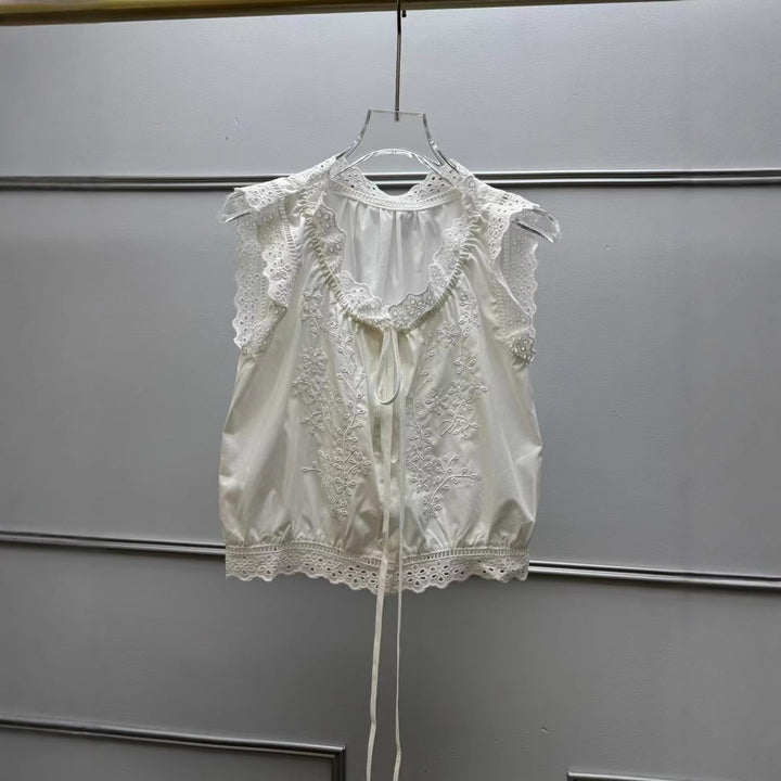Damebluse med sarte spidsdetaljer og floralt broderidesign Stilla
