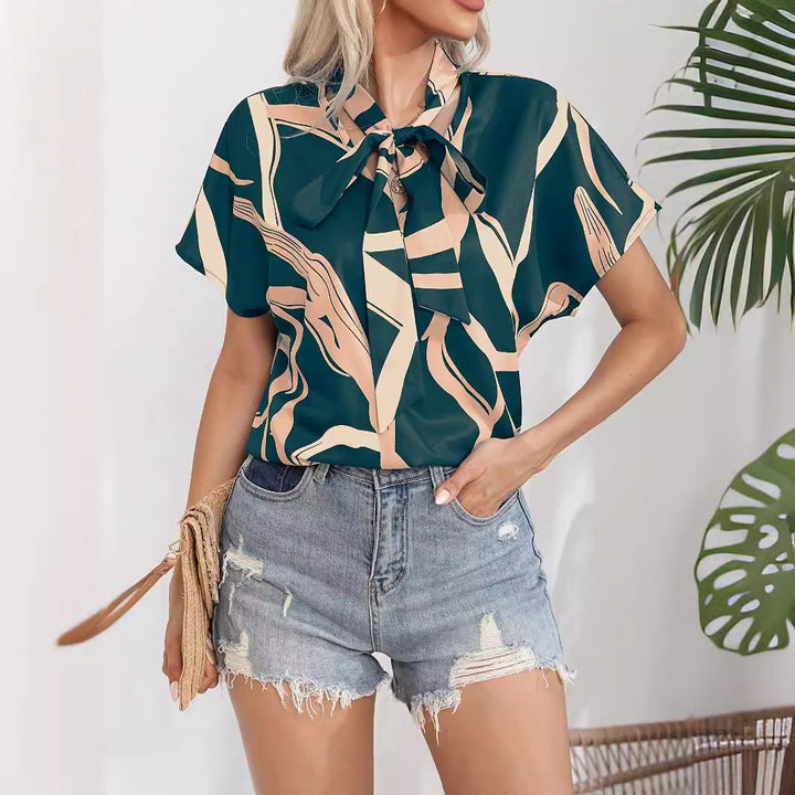 Damebluse med flot sløjfekrave og moderne grafisk design Stilla