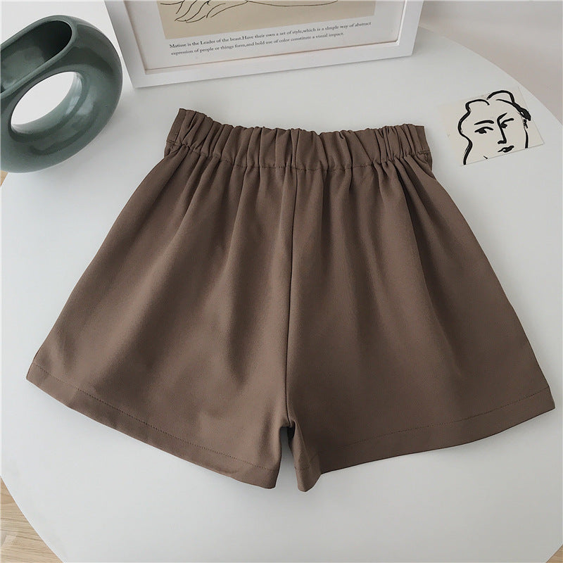 Kvinders elegante shorts med plisseringer og knapdetalje