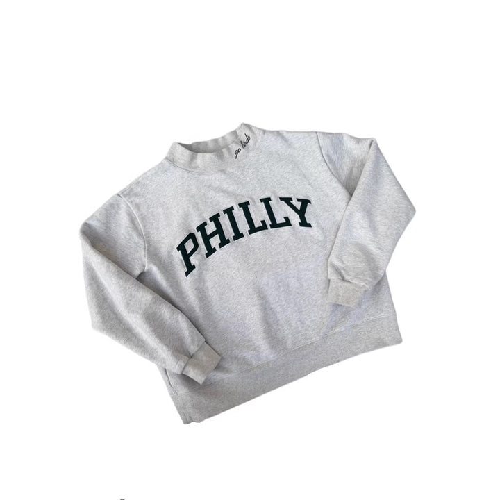 Dame med vid skåret college-sweatshirt med høj krave og påsyet skrift Skovae