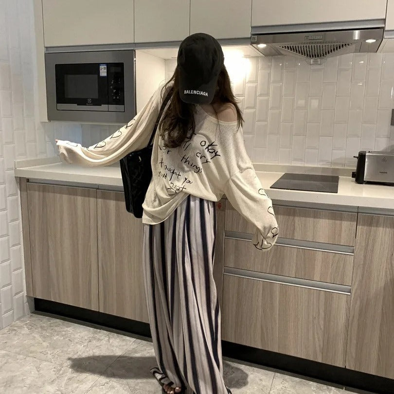 Kvinders afslappede oversized top med off-shoulder design og kunstnerisk skrifttype Stilla
