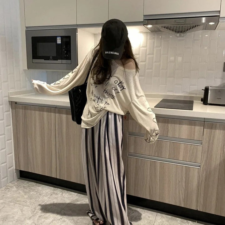 Kvinders afslappede oversized top med off-shoulder design og kunstnerisk skrifttype Stilla