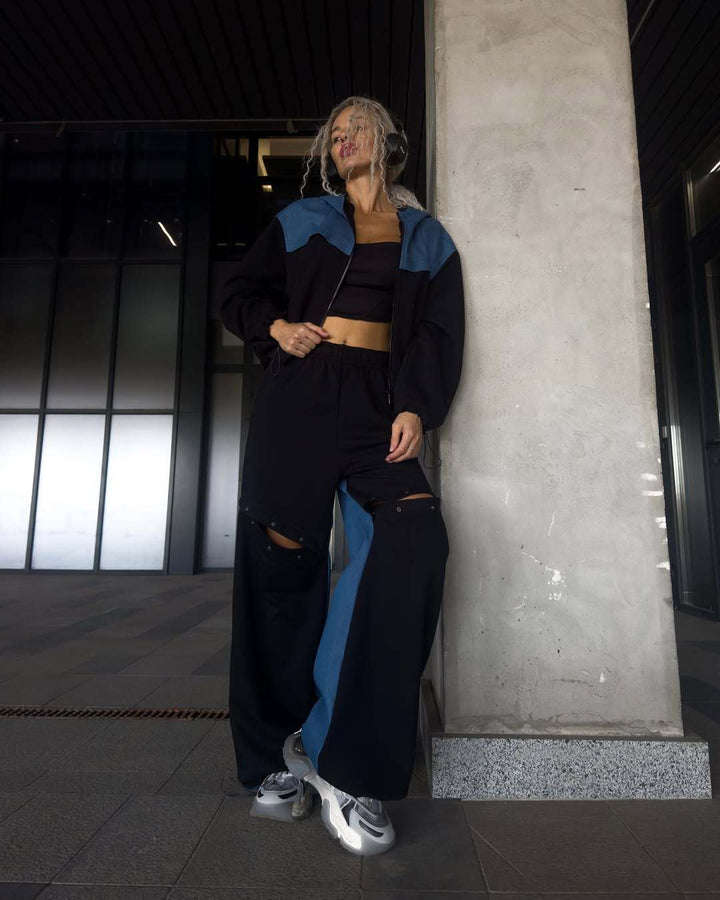 Kvinders fashionable casual outfit med sporty jakke og kreativt udskårne bukser Skovae