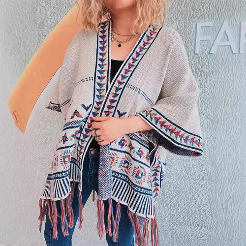 Damer fashionabel strikket poncho med frynset kant og farverigt mønster Stilla