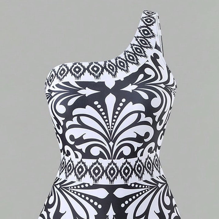 Dame one-piece badedragt med elegant asymmetrisk design og matchende bukser Skovae