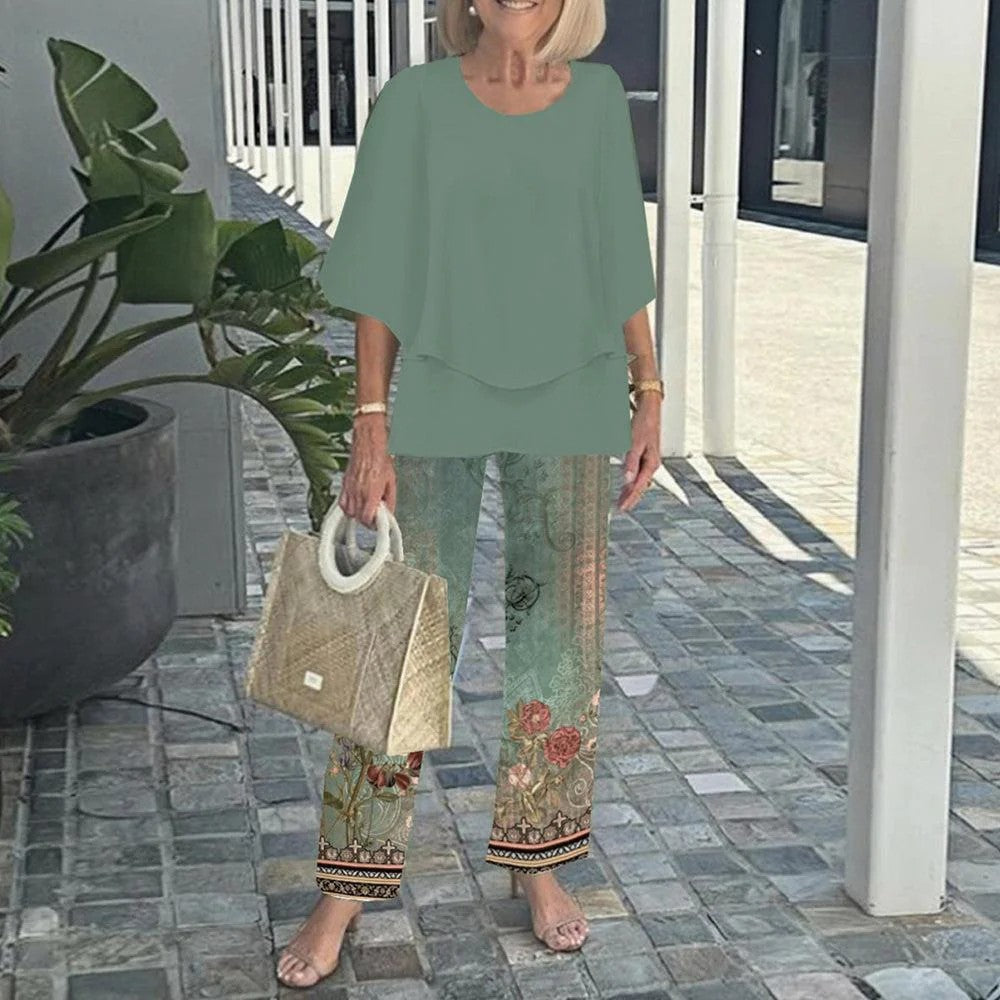 Dame med lagdelt tunika med capærmer og ankel-lang lige bukser med grafikprint Skovae