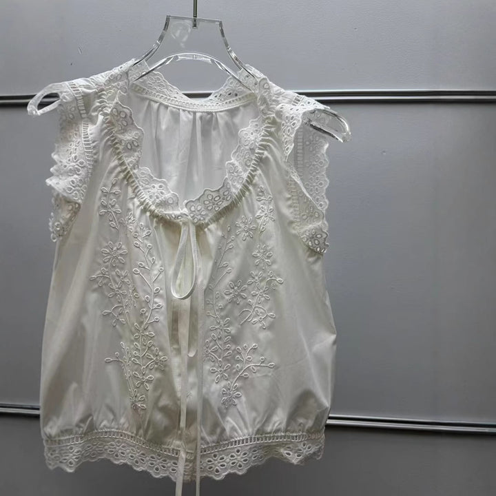 Damebluse med sarte spidsdetaljer og floralt broderidesign Stilla