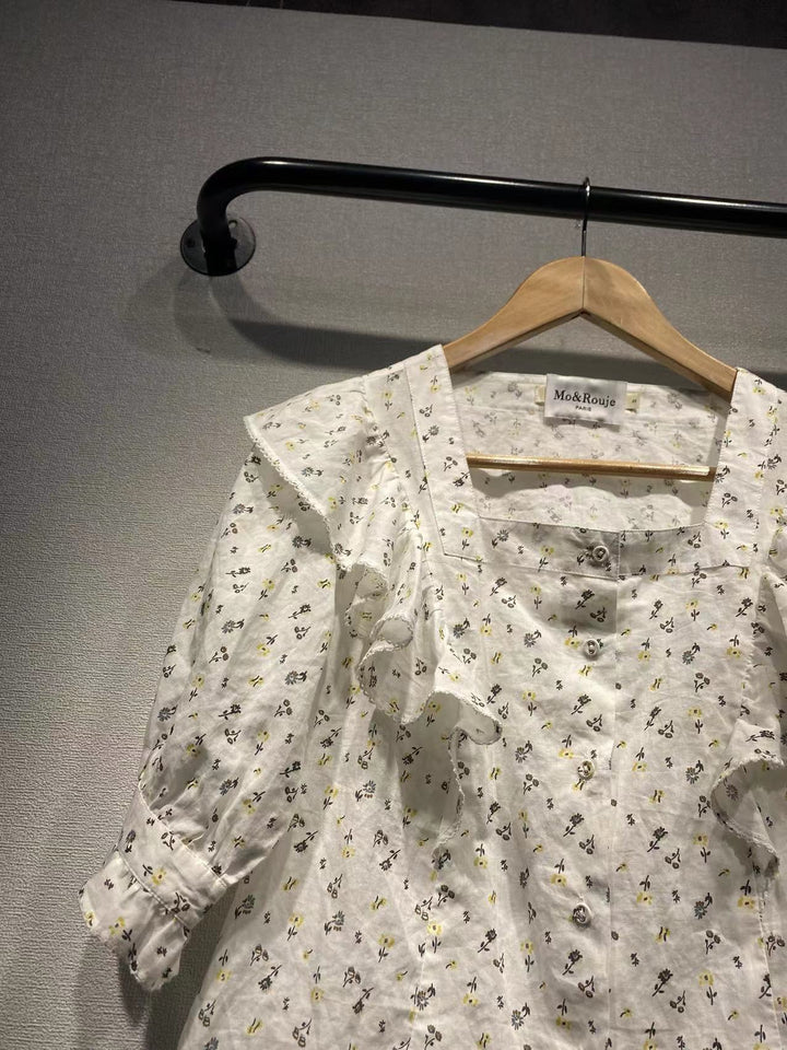 Damebluse med elegante flæsedetaljer og blomstret mønster Stilla
